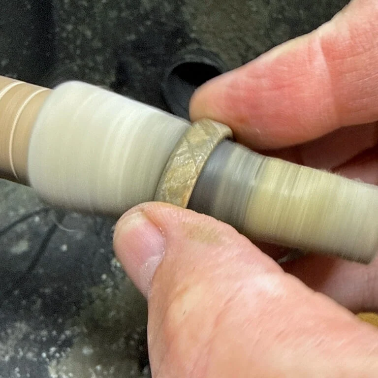 Polishing the tantalum liner inside a meteorite ring after etching.